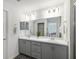 Bright bathroom featuring double sinks, white countertops, and gray cabinetry at 5958 164Th E Ave, Parrish, FL 34219