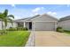 Inviting single-story home with a two-car garage, showcasing lush landscaping and a well-maintained lawn on a sunny day at 5958 164Th E Ave, Parrish, FL 34219