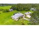 Sweeping aerial perspective showcases a home with a pool area, outbuildings and expansive greenery at 5981 Jim Davis Rd, Parrish, FL 34219