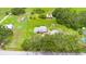 Expansive aerial perspective captures a home set amidst vast green land, accompanied by outbuildings and a pool at 5981 Jim Davis Rd, Parrish, FL 34219
