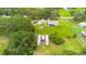 Lush aerial shot of a home with screened pool, stock tank pool, outbuildings and verdant landscape at 5981 Jim Davis Rd, Parrish, FL 34219