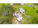 Aerial view of a yellow home with a large green yard with trees and other shrubbery at 5981 Jim Davis Rd, Parrish, FL 34219