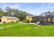 A full view of the backyard showing a building detached, a large yard and screened-in patio at 5981 Jim Davis Rd, Parrish, FL 34219