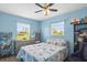Inviting bedroom with blue walls, bright windows with backyard views, and decorative shelving at 5981 Jim Davis Rd, Parrish, FL 34219
