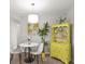 Cozy dining area with a round table, chairs, pendant lighting, and a bright yellow cabinet at 5981 Jim Davis Rd, Parrish, FL 34219