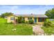 Charming yellow single-story home with an American flag in the front yard at 5981 Jim Davis Rd, Parrish, FL 34219