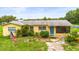 Charming single-story home with a well-manicured lawn and a bright blue front door at 5981 Jim Davis Rd, Parrish, FL 34219
