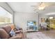 Comfortable living room with couch, TV, ceiling fan, and view of the kitchen at 5981 Jim Davis Rd, Parrish, FL 34219