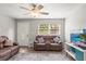 Open living room with loveseat, TV, ceiling fan, front door and bright lighting at 5981 Jim Davis Rd, Parrish, FL 34219