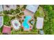 An aerial view of a community pool, splash pad, volleyball court, basketball court, and playground surrounded by trees at 6306 Anise Dr, Sarasota, FL 34238