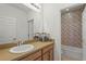 Well-lit bathroom with a sink vanity and view into the adjacent bath/shower with colorful tiled accent wall at 6306 Anise Dr, Sarasota, FL 34238