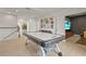 This large bonus room has an air hockey table, a sofa, and beautiful wood laminate flooring at 6306 Anise Dr, Sarasota, FL 34238