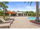 A community pool and clubhouse surrounded by palm trees and lounge chairs at 6306 Anise Dr, Sarasota, FL 34238