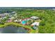 An aerial perspective shows a neighborhood pool, volleyball court, and nearby lake at 6306 Anise Dr, Sarasota, FL 34238