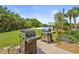 A community grilling area with two grills on a brick patio and a volleyball court in the background at 6306 Anise Dr, Sarasota, FL 34238