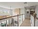 Upstairs hallway with wood flooring, white banister and view to the living room and the book room at 6306 Anise Dr, Sarasota, FL 34238