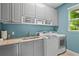 Bright laundry room with washer, dryer, granite counters and cabinets for storage at 6306 Anise Dr, Sarasota, FL 34238
