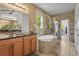 This bathroom features a soaking tub with shower, tile walls, dual sinks, and a granite countertop at 6306 Anise Dr, Sarasota, FL 34238