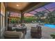 Covered outdoor patio features a fire pit and lounge chairs overlooking the screened-in pool at 6306 Anise Dr, Sarasota, FL 34238