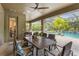 A covered patio with a dining table, overlooking a screened-in pool and lush landscaping at 6306 Anise Dr, Sarasota, FL 34238