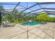 Inviting screened-in pool with lounge chairs, lush palm trees, and open sky views at 6306 Anise Dr, Sarasota, FL 34238