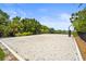 A sand volleyball court with a net and trees surrounding it at 6306 Anise Dr, Sarasota, FL 34238