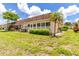 Back exterior view of home with mature landscaping, windows, and lawn at 643 Park Cir, Bradenton, FL 34207