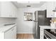 Kitchen view with a stainless steel refrigerator and white countertops that lead to a connecting living space at 643 Park Cir, Bradenton, FL 34207