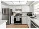 Bright kitchen with stainless steel appliances, white cabinetry, and quartz countertops at 643 Park Cir, Bradenton, FL 34207