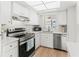 Updated kitchen with white cabinets, stainless steel appliances, modern lighting, and stainless sink at 643 Park Cir, Bradenton, FL 34207