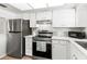 Clean kitchen featuring modern stainless steel appliances, white cabinets, and plenty of counter space at 643 Park Cir, Bradenton, FL 34207