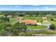 Aerial view showcasing multiple residences, a green riding area, and lush greenery at 7025 Saddle Creek Cir, Sarasota, FL 34241