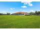 Expansive backyard featuring a large grassy lawn and a screened-in back patio at 7025 Saddle Creek Cir, Sarasota, FL 34241