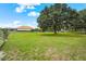 Lush green backyard with mature trees and partial view of screened in back porch of home at 7025 Saddle Creek Cir, Sarasota, FL 34241