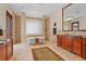 A luxury bathroom showcases a soaking tub, tiled shower, and and wooden vanities with granite countertops at 7025 Saddle Creek Cir, Sarasota, FL 34241