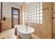 This elegant bathroom features a clawfoot tub, tile walls, and a glass block window for natural light at 7025 Saddle Creek Cir, Sarasota, FL 34241