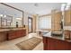 Large bathroom features a clawfoot tub, dual vanities, a glass block window, and tile flooring at 7025 Saddle Creek Cir, Sarasota, FL 34241