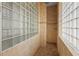 Elegant bathroom featuring walk-in shower with glass block and decorative tile accents at 7025 Saddle Creek Cir, Sarasota, FL 34241