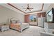 Spacious bedroom features a tray ceiling with wood trim, a ceiling fan, and a large window for natural light at 7025 Saddle Creek Cir, Sarasota, FL 34241