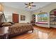 Bedroom with hardwood floors, decorative window seat, shelves, ceiling fan and a traditional bed at 7025 Saddle Creek Cir, Sarasota, FL 34241