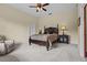 Primary bedroom showcasing a traditional bed, carpet floors, and a matching nightstand and lamp at 7025 Saddle Creek Cir, Sarasota, FL 34241