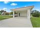 Open air two car carport showing the entrance to the home, which is nestled on a well manicured lawn at 7025 Saddle Creek Cir, Sarasota, FL 34241