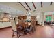 Open dining area with wood table and chairs, terra cotta tile flooring, chandelier and open access to kitchen at 7025 Saddle Creek Cir, Sarasota, FL 34241