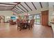 Elegant dining room features high ceilings with wood beams, tile floors and sliding glass doors to the outside at 7025 Saddle Creek Cir, Sarasota, FL 34241