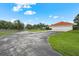 Long paved driveway leading to a home with a three-car garage and well-maintained landscaping at 7025 Saddle Creek Cir, Sarasota, FL 34241