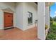 Home entrance with a decorative wooden door, tile flooring and lush landscaping at 7025 Saddle Creek Cir, Sarasota, FL 34241