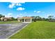 The property features a well-maintained lawn, long driveway and ample parking space with a light orange tiled roof at 7025 Saddle Creek Cir, Sarasota, FL 34241