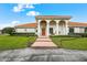 Luxury home exterior featuring a well-manicured lawn and brick pathway leading to the front door at 7025 Saddle Creek Cir, Sarasota, FL 34241