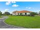 Stunning exterior elevation featuring a well-manicured lawn and a circular driveway at 7025 Saddle Creek Cir, Sarasota, FL 34241