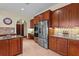 Kitchen with stainless steel appliances, wood cabinetry, and tile floors at 7025 Saddle Creek Cir, Sarasota, FL 34241